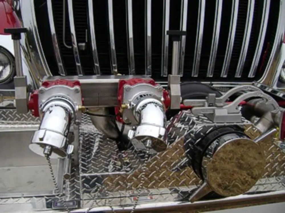 Exterior view of small fire truck showing cab, body compartments, and wheel/tire area.