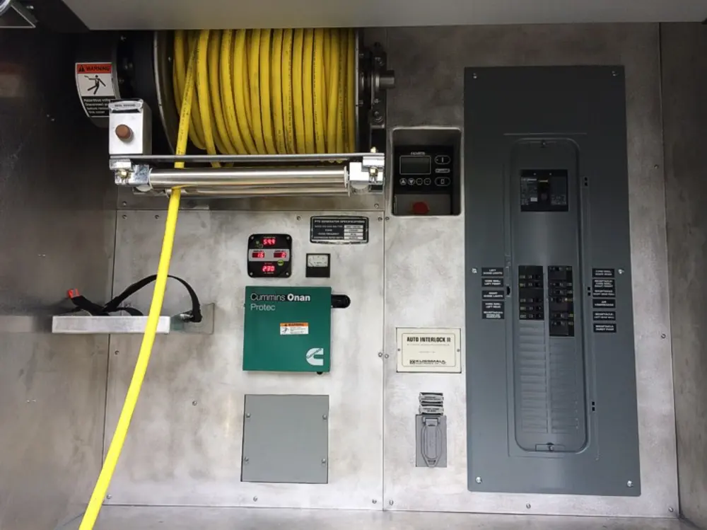 Exterior view of small fire truck showing cab, body compartments, and wheel/tire area.