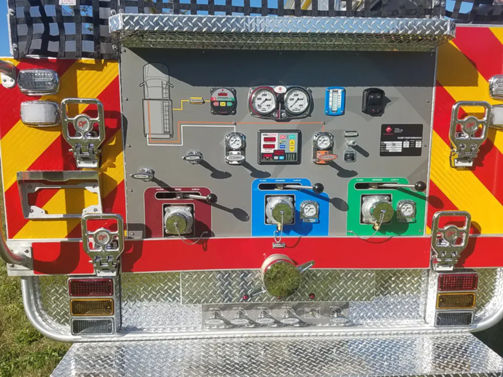 Exterior view of small fire truck showing cab, body compartments, and wheel/tire area.