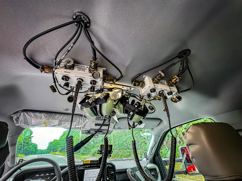 Overhead mounted electronics and wiring cluster above windshield.