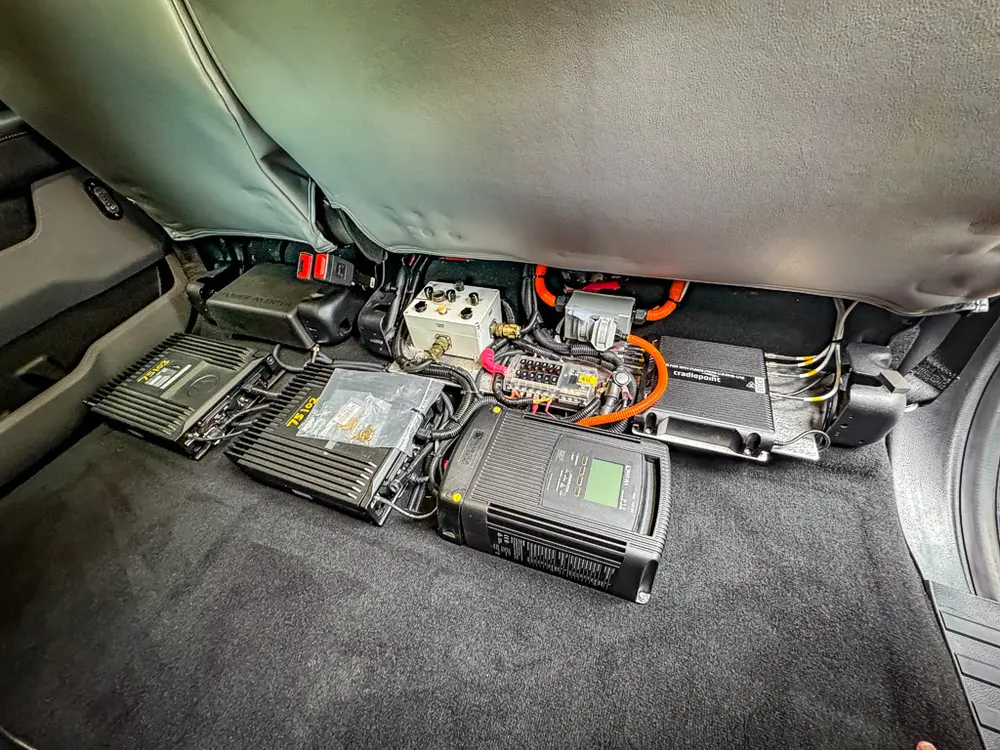 Rear floor electronics modules and wiring under folded panel.