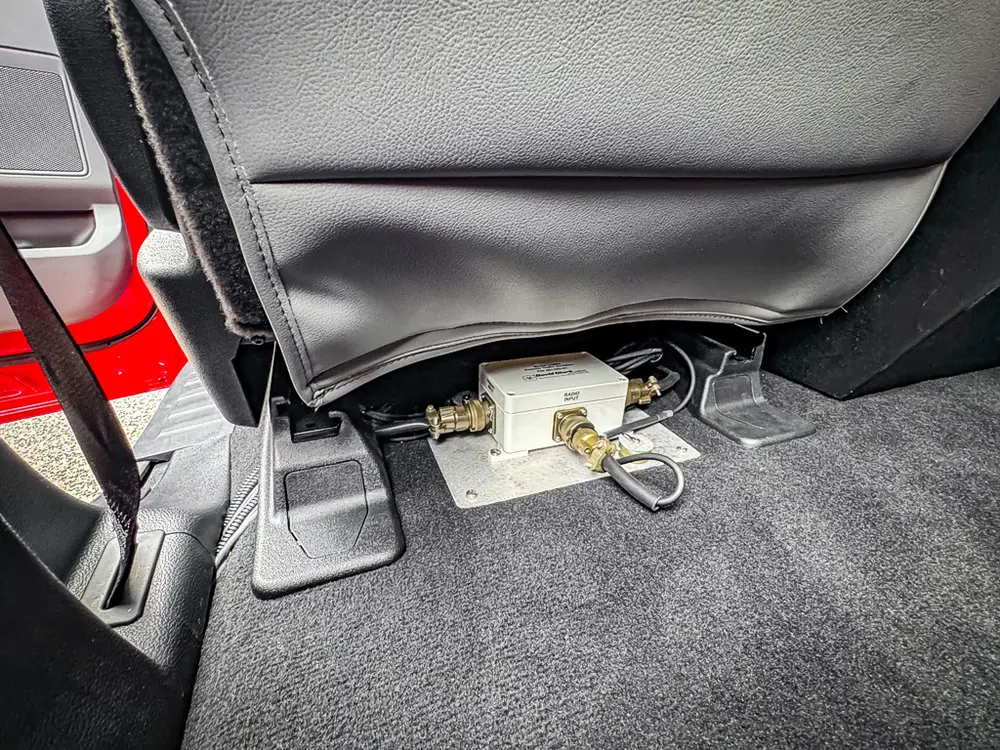 Under-seat wiring and connector close-up at rear footwell.