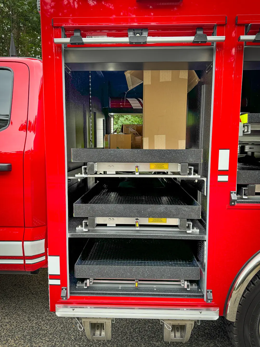 Open side compartment with slide-out tray and boxed items.