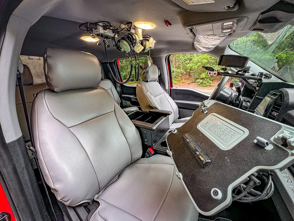 Passenger-side interior view with fold-down work surface and devices.