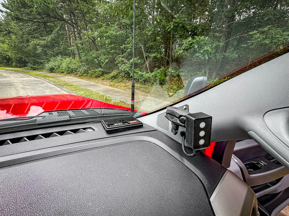 Front passenger dash corner close-up with mounted black device.