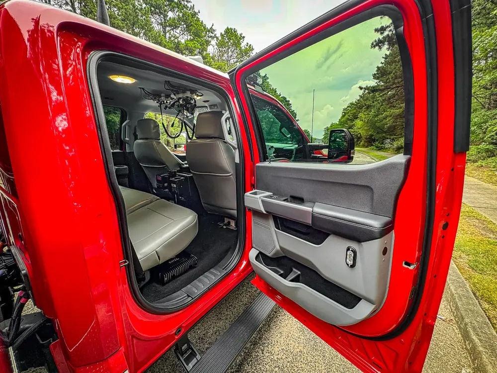 Open rear passenger door with rear seat and floor area visible.