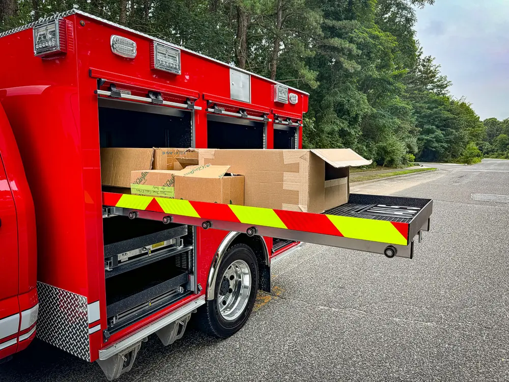 Long slide-out tray extended from side compartment with boxes on top.