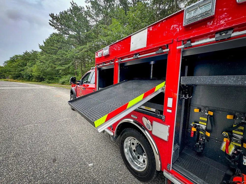 Wide right-side view with multiple compartments open and large slide-out tray extended.