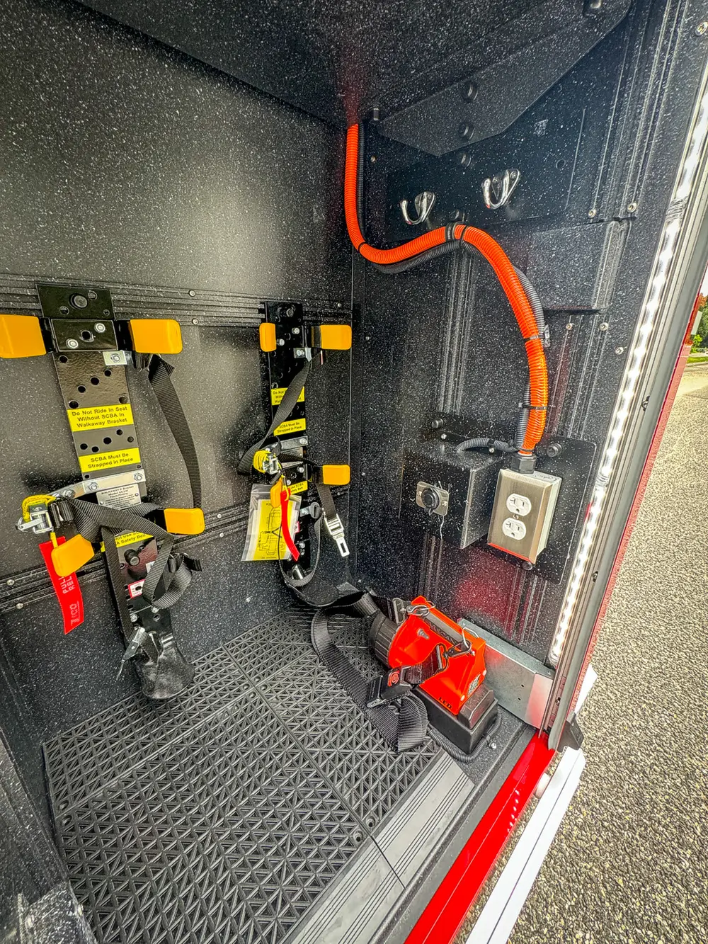 Close-up of vertical equipment panel with orange wiring and switches.