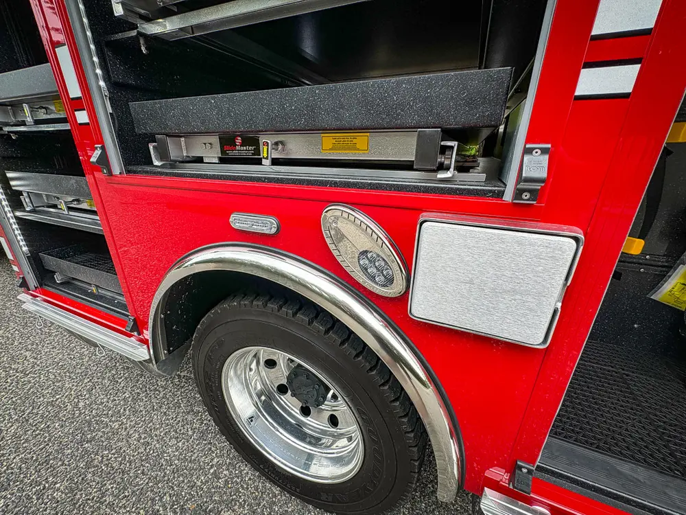 Lower side panel near rear wheel with compartment opening above.