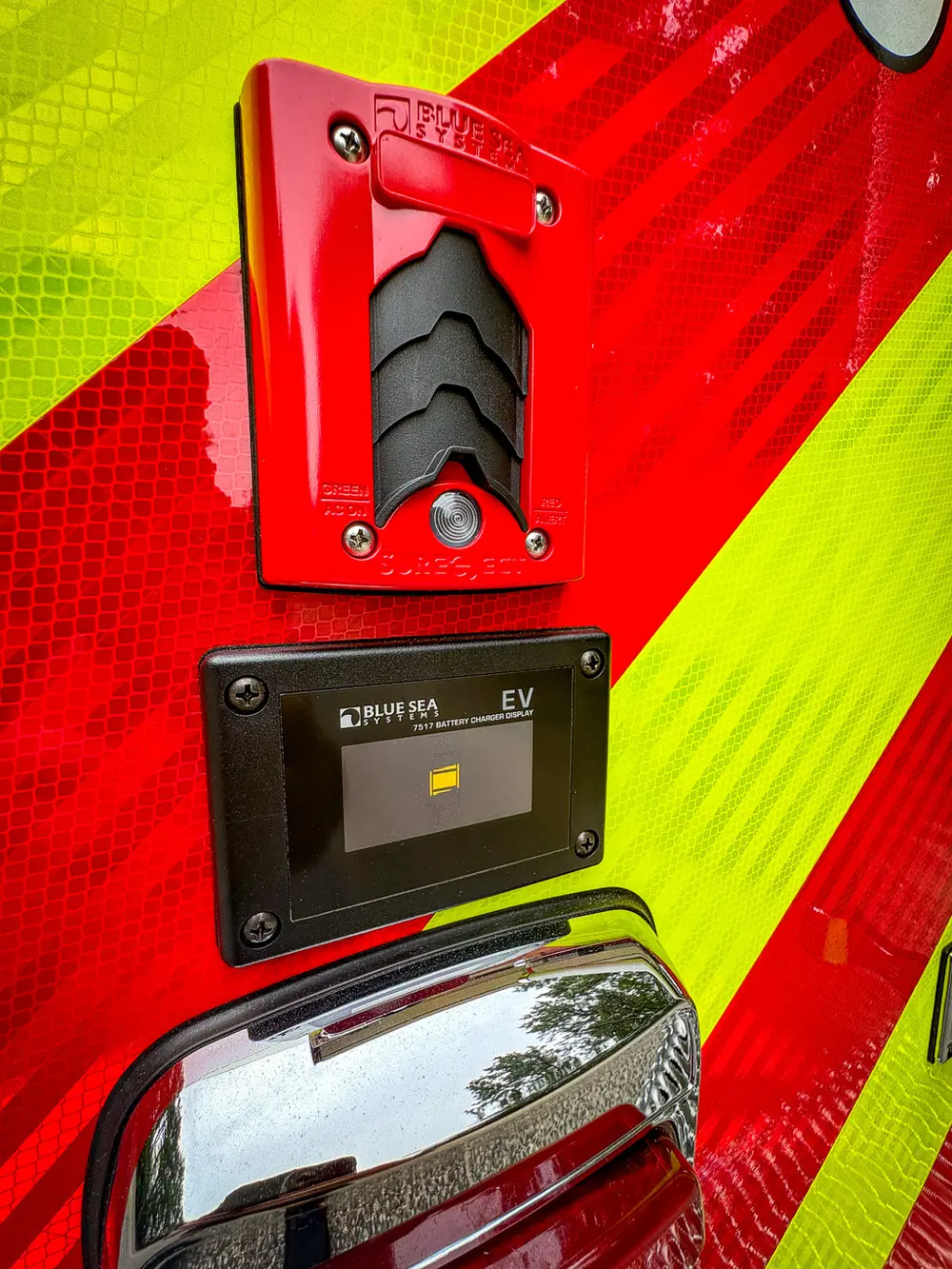 Small rear panel control close-up on red-and-yellow chevron surface.