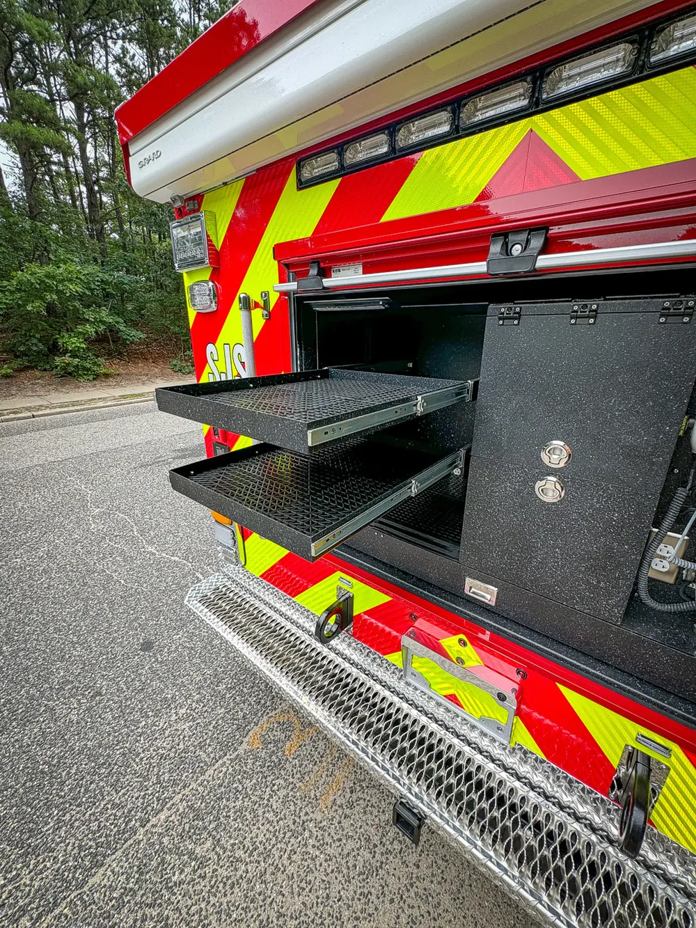 Rear compartment with lower slide-out tray extended and equipment bay exposed.