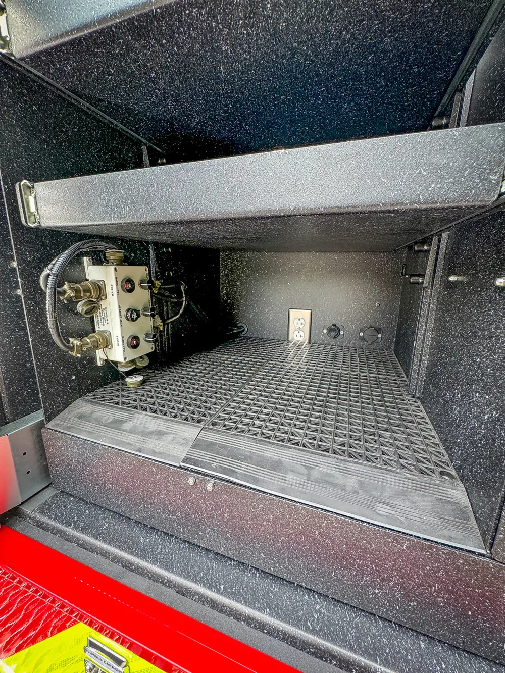 Rear bay close-up with mounted fittings and outlet inside compartment.