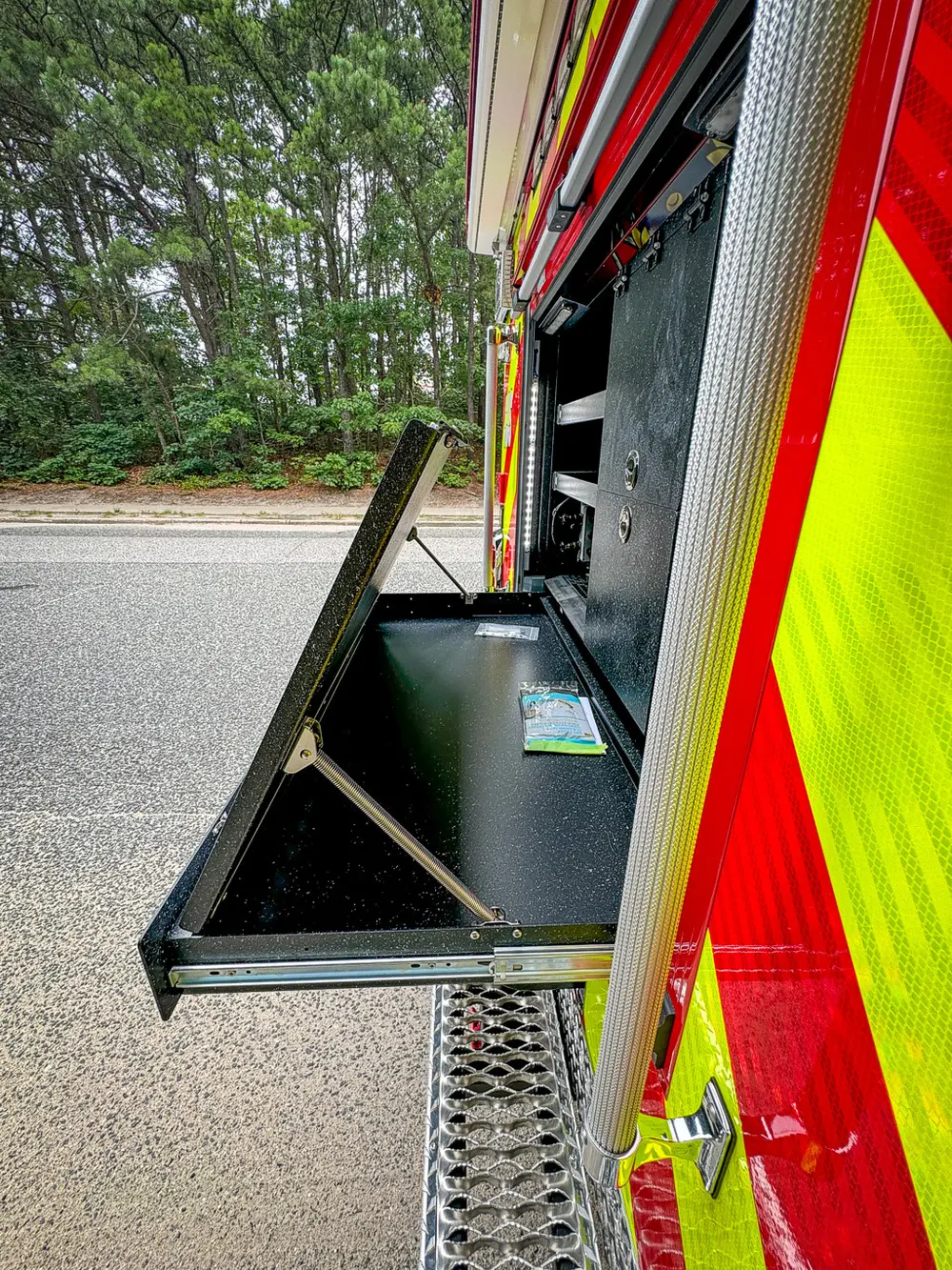 Narrow vertical rear-side bay showing interior wall and mounted hardware.
