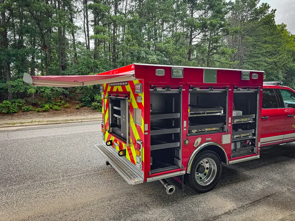 Rear-right three-quarter view with multiple compartment doors open.