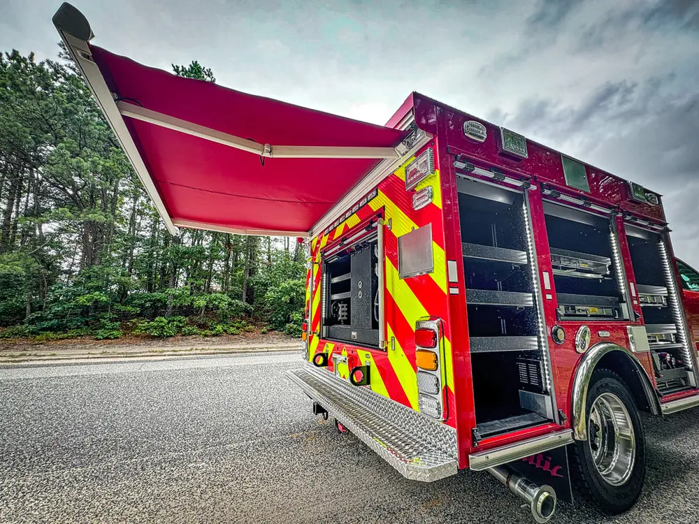 Rear-left angle showing open upper hatch and open side compartments.