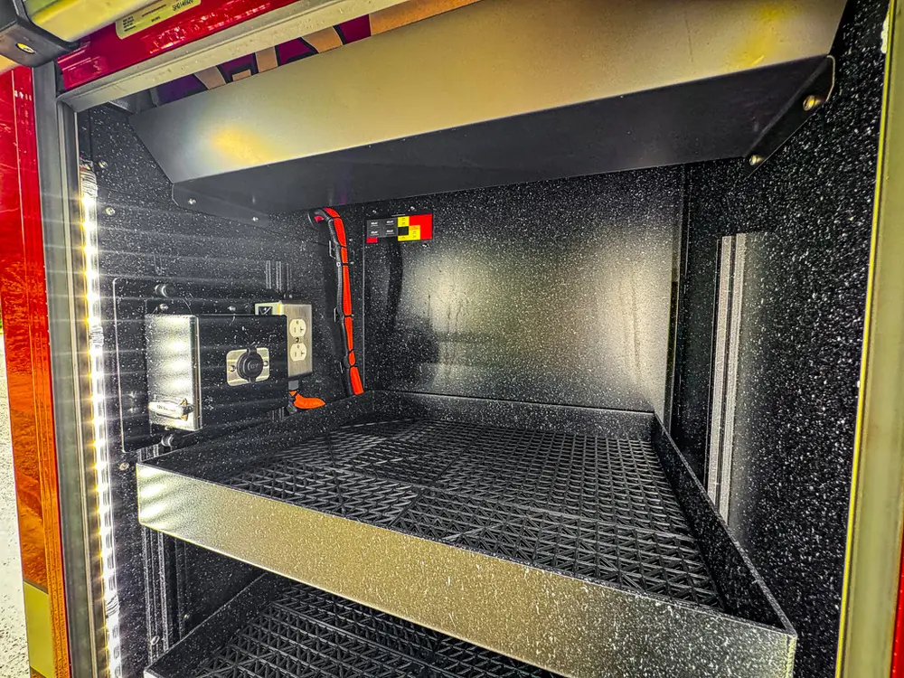 Deep side compartment interior with shelf and wiring visible at rear.