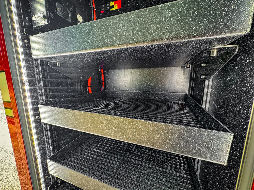 Side compartment close-up with empty shelves and black anti-slip surfaces.