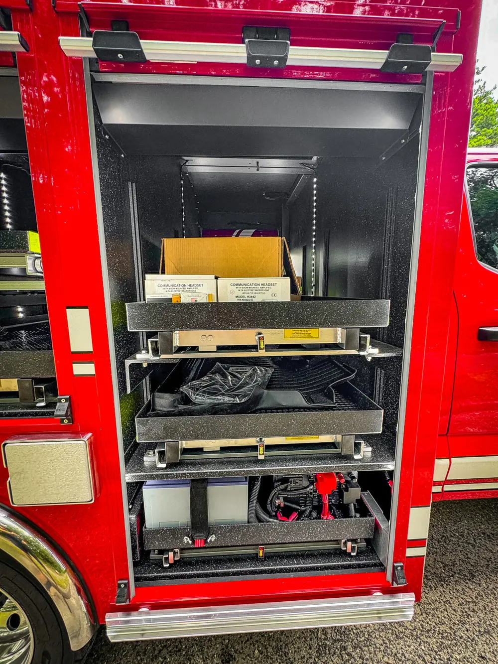 Open side compartment with two pull-out trays and cardboard boxes.