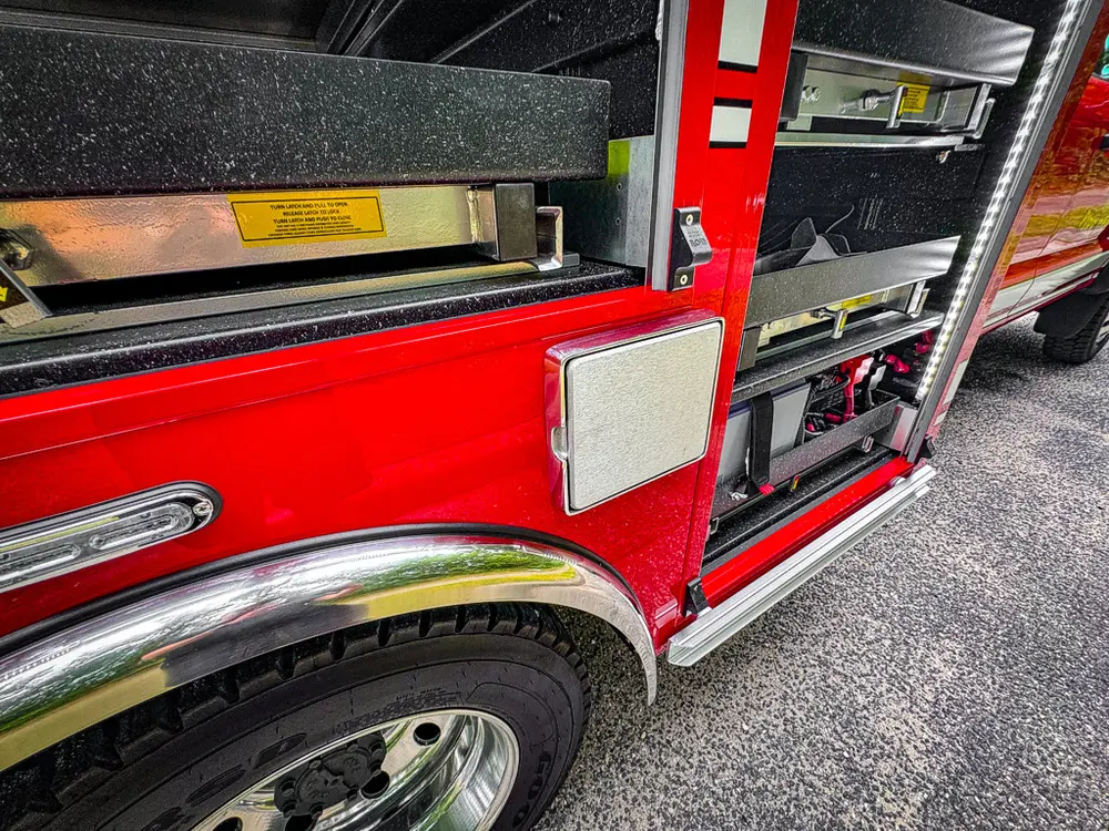 Close-up of long side compartment with nested shelves and latch panel.