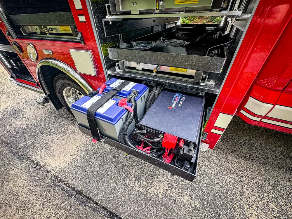 Lower pull-out battery/equipment drawer extended from side compartment.