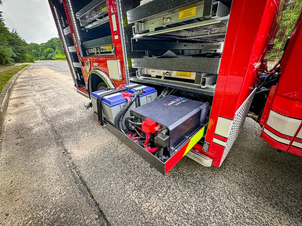 Open lower side bay with dual battery trays and cable management.