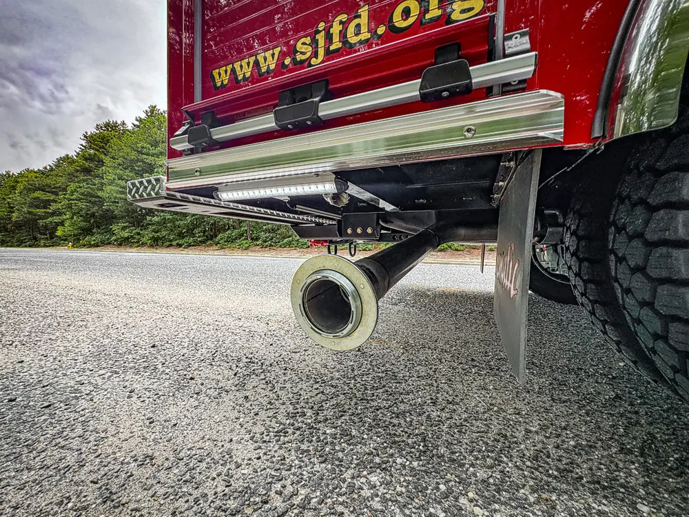 Rear underside close-up showing exhaust outlet and bumper edge.