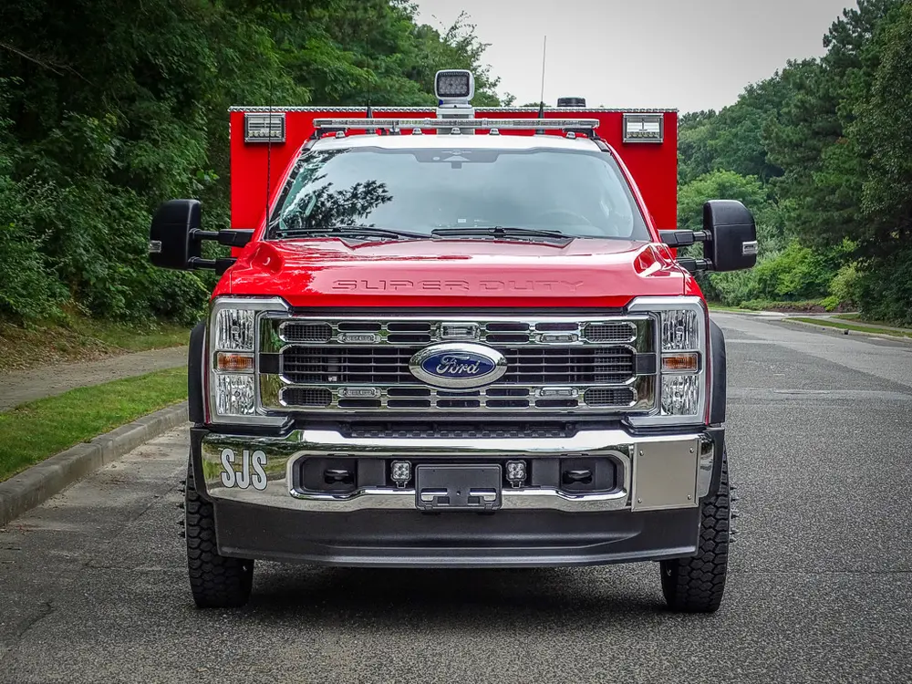 Head-on front view showing grille, bumper, and roof lights.