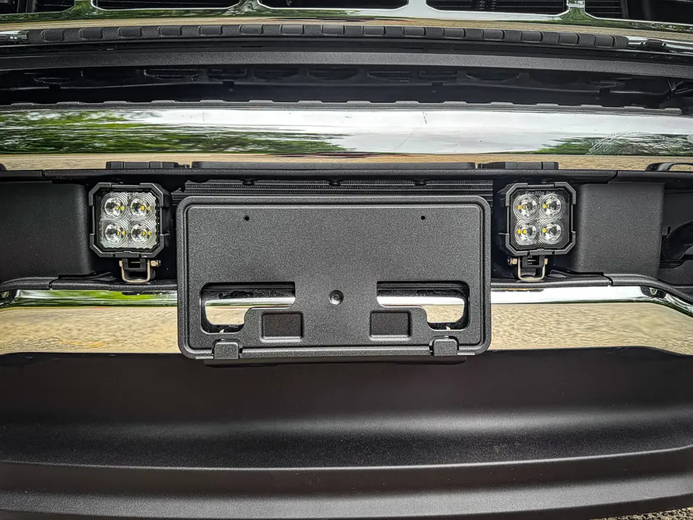 Front bumper close-up with plate mount and dual auxiliary lights.
