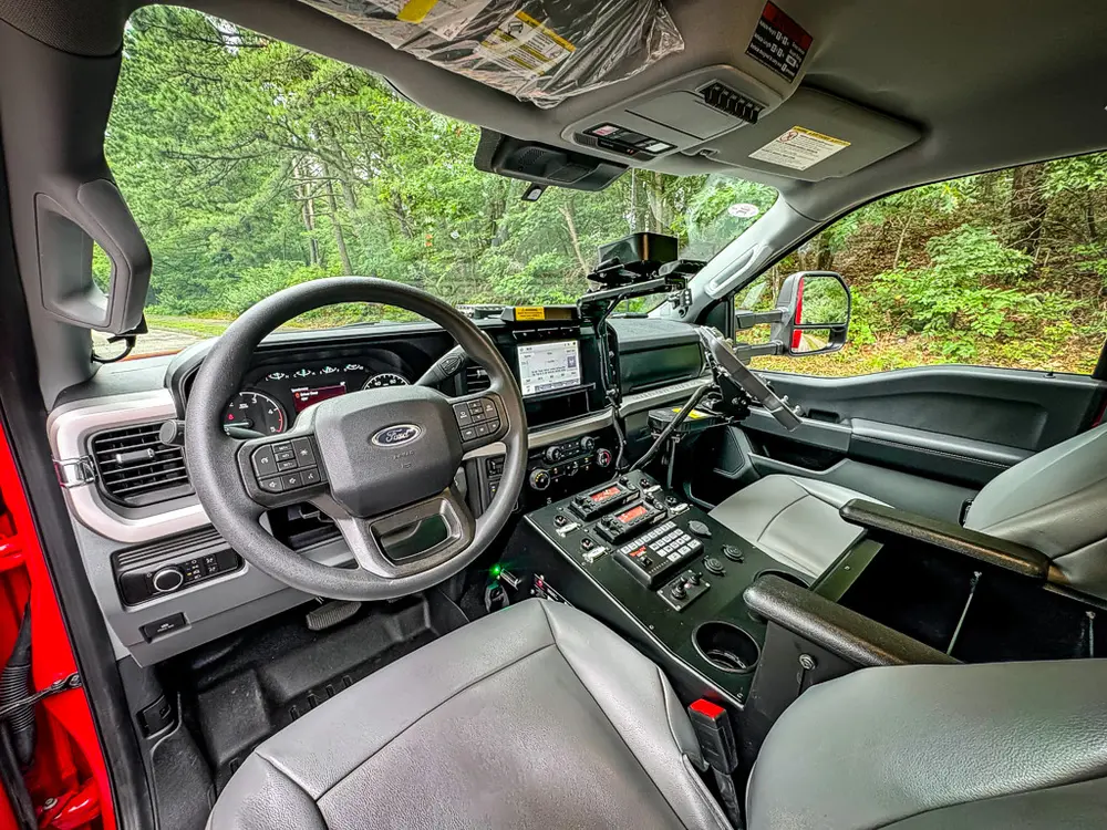 Front cabin interior view with steering wheel and center controls.