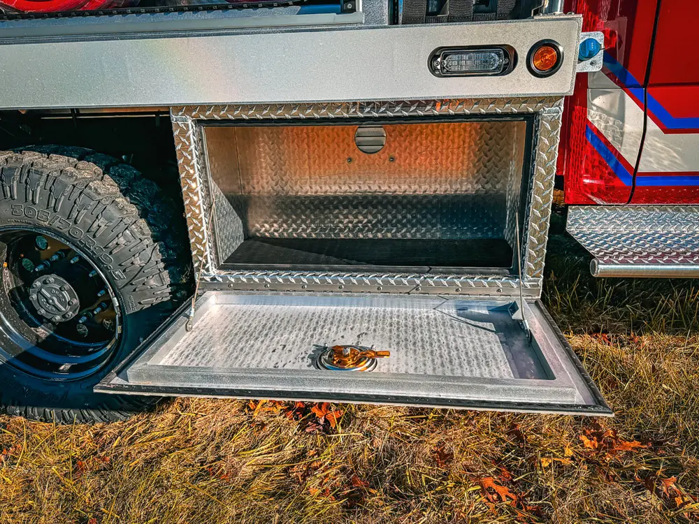 Open lower side compartment close-up with diamond-plate floor.