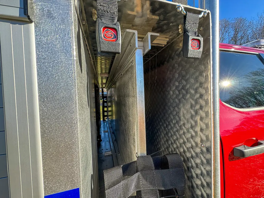 Narrow vertical compartment with mounted extinguisher and hardware.