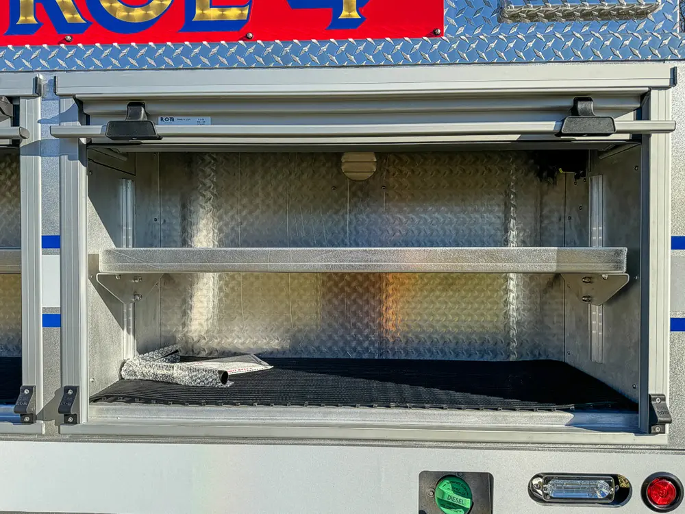 Open side compartment with shelf and clean metal interior.