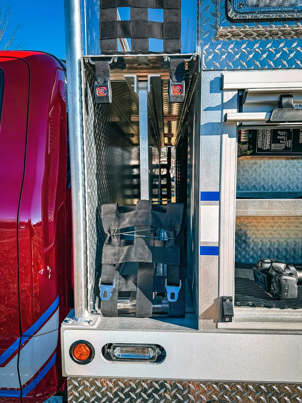 Vertical side rack close-up with mounted red gear packs and straps.