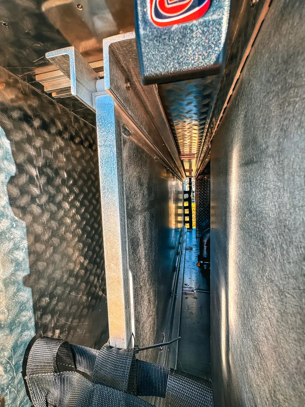 Narrow vertical storage channel behind side compartment with ladder-like rack.