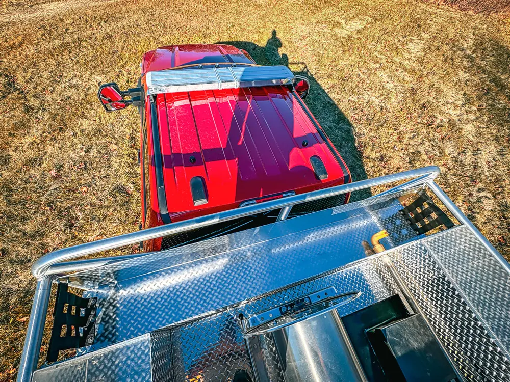 Rear-to-front top view over red cab roof and grated deck.