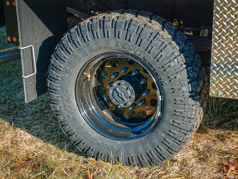 Front wheel close-up showing off-road tire and wheel hub.
