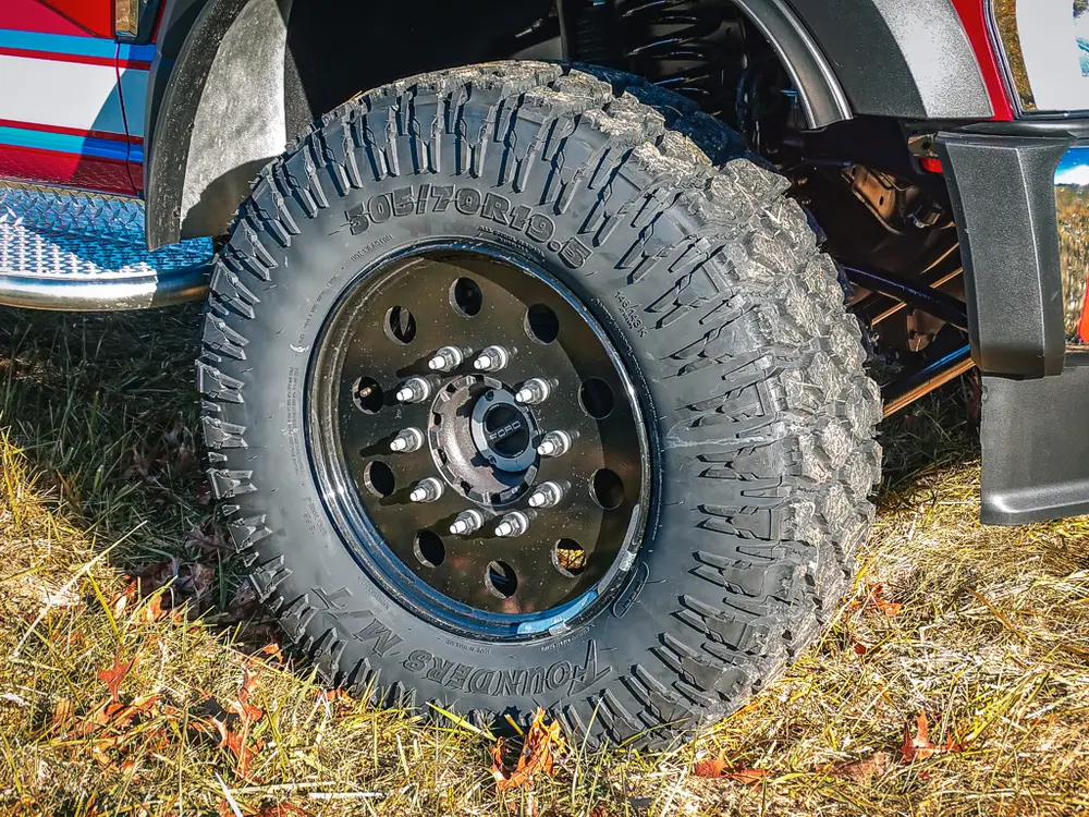 Rear wheel close-up with aggressive tread and suspension clearance.