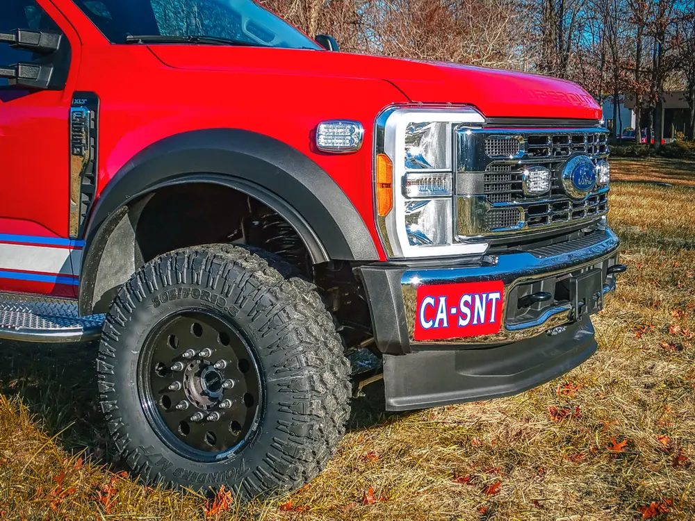 Front-right corner view showing grille, bumper, and wheel.