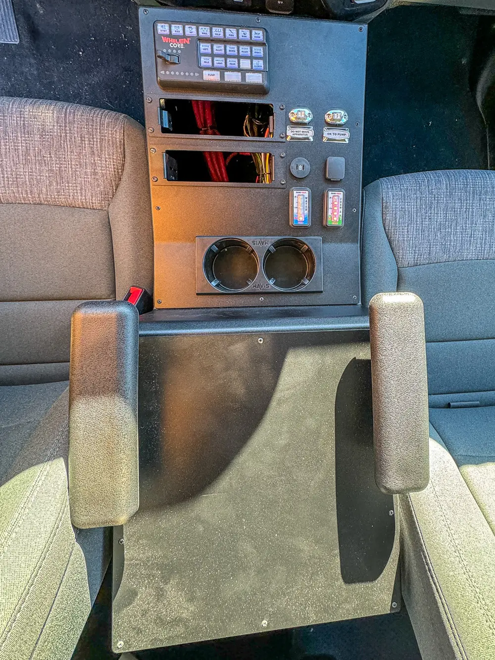 Rear center console close-up with cup holders and control dials.