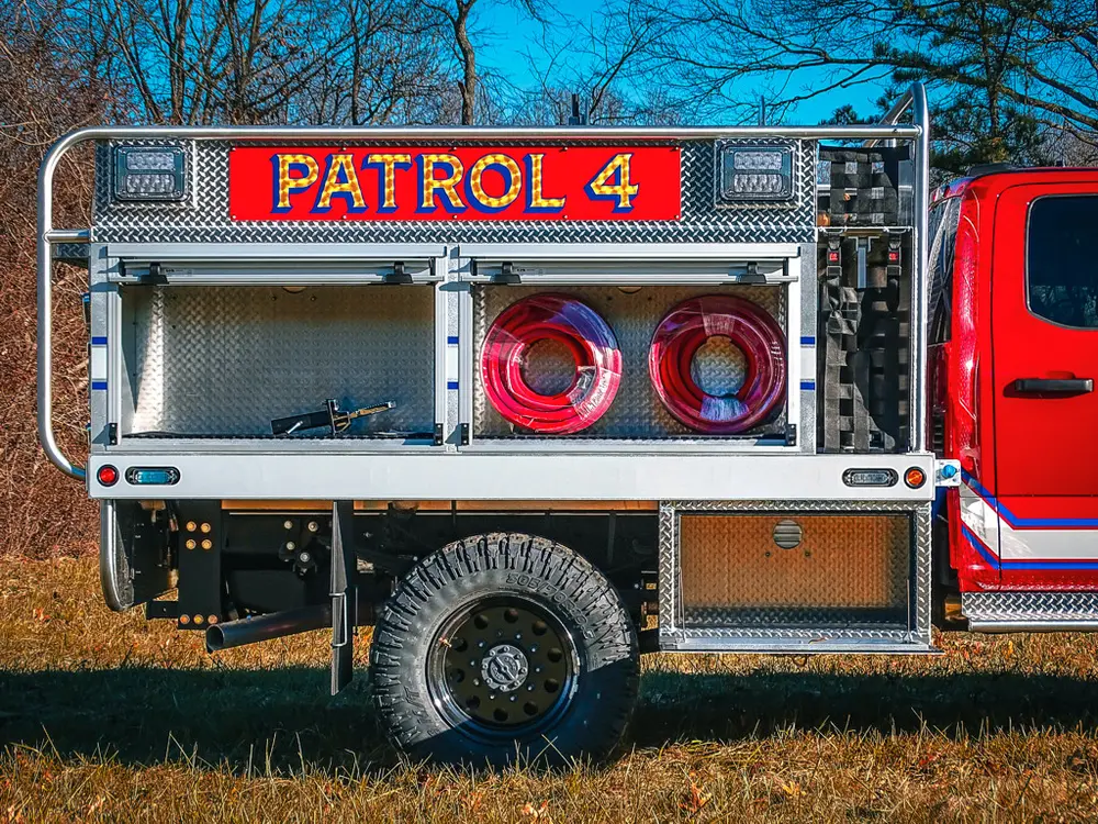 Right-side rear section close-up with hose reels and open bay.