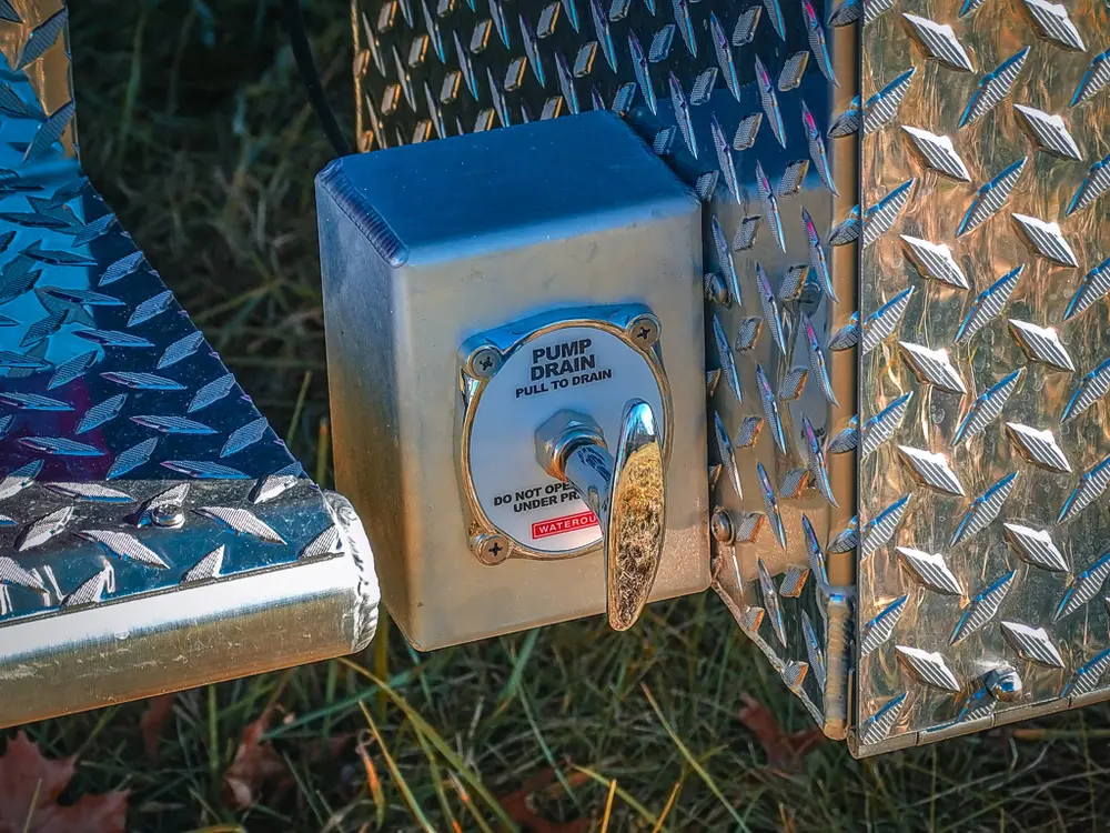 Exterior side panel close-up with electrical inlet and diamond-plate trim.