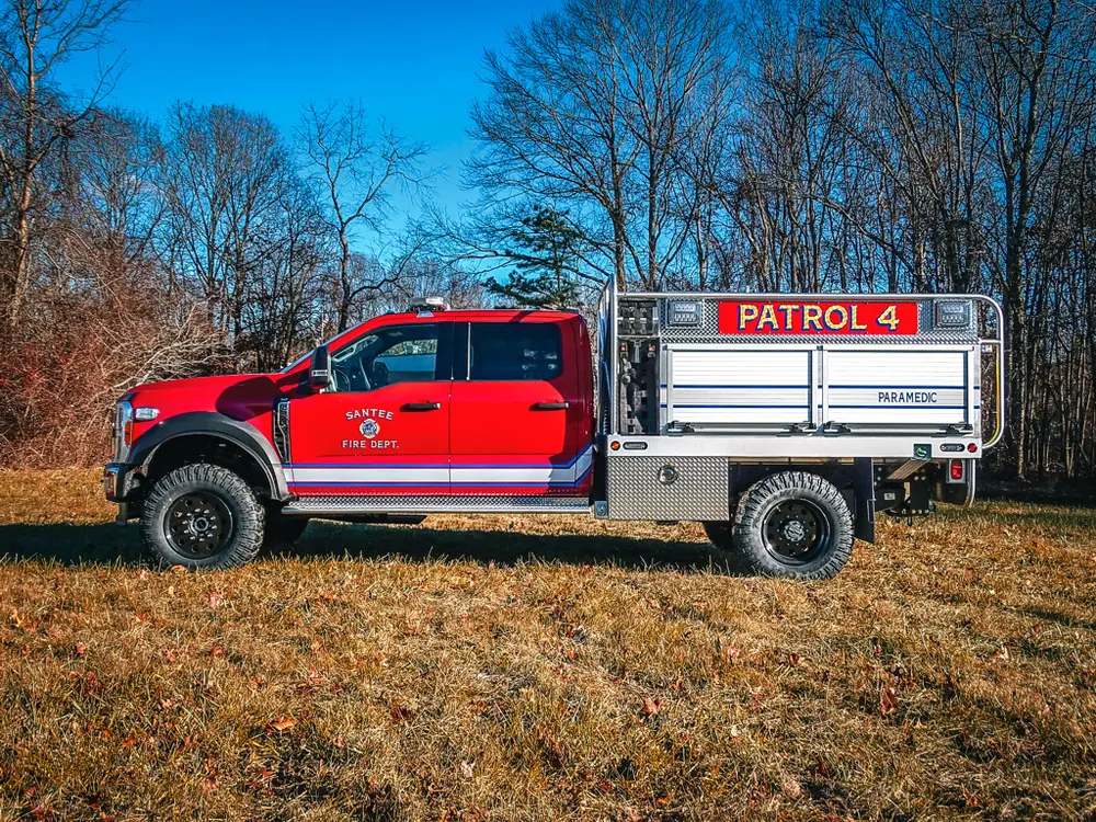 Full right-side profile parked on grass with rear body rails.