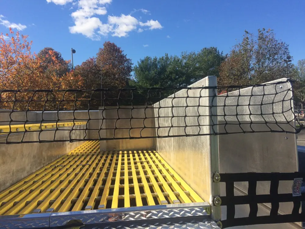 Exterior view of small fire truck showing cab, body compartments, and wheel/tire area.