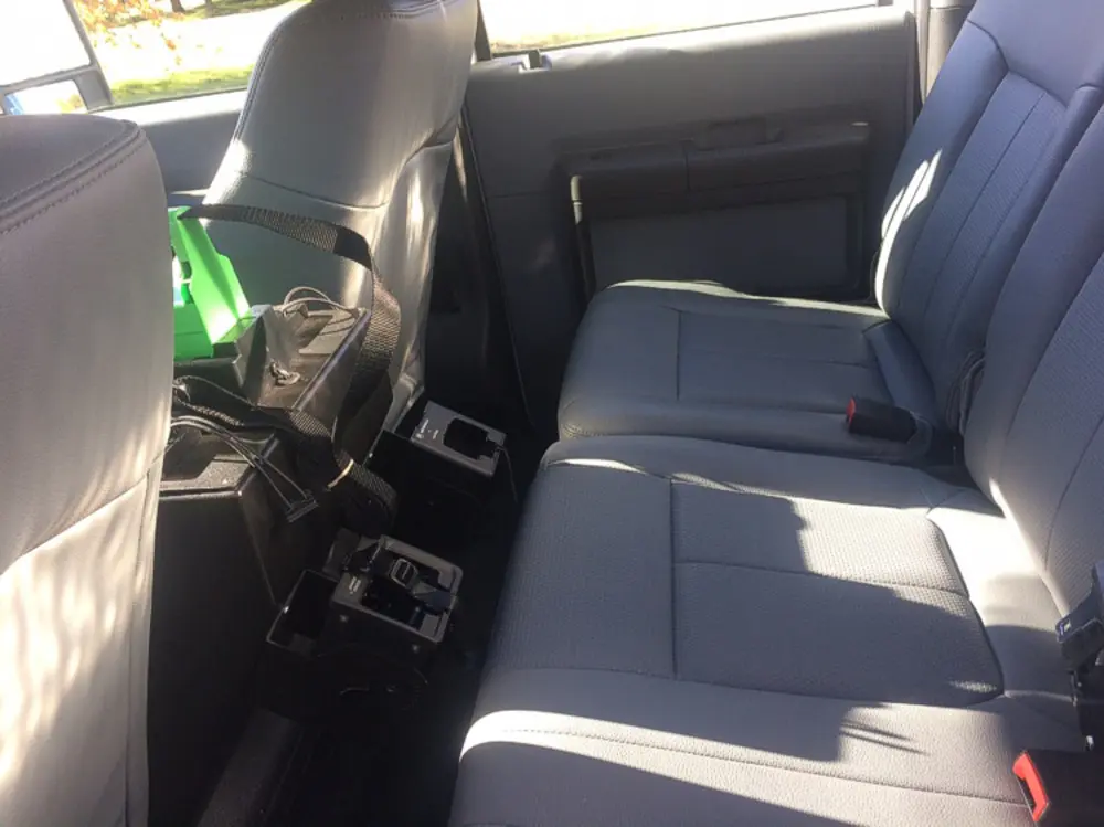 Exterior view of small fire truck showing cab, body compartments, and wheel/tire area.