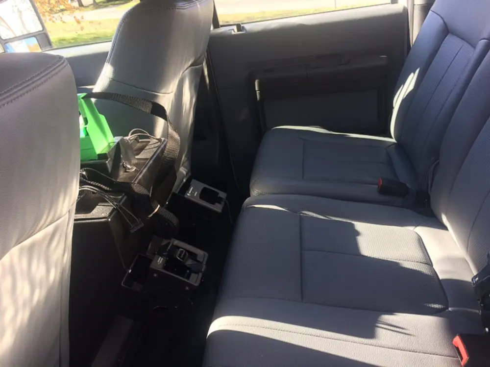 Exterior view of small fire truck showing cab, body compartments, and wheel/tire area.