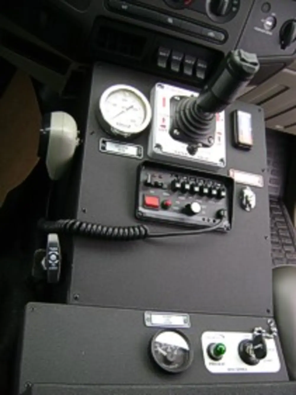 Exterior view of small fire truck showing cab, body compartments, and wheel/tire area.