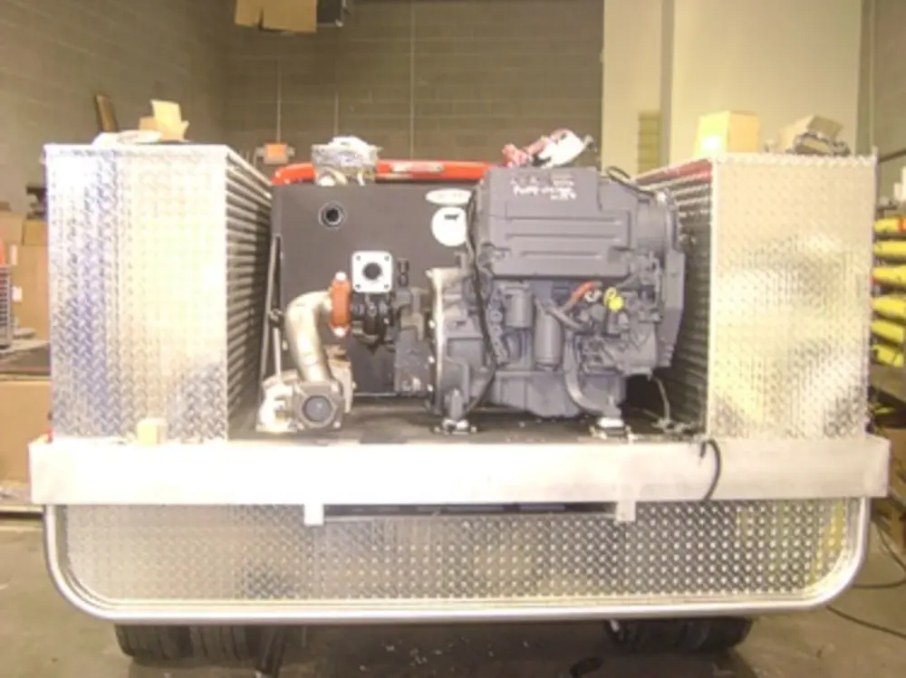 Exterior view of small fire truck showing cab, body compartments, and wheel/tire area.