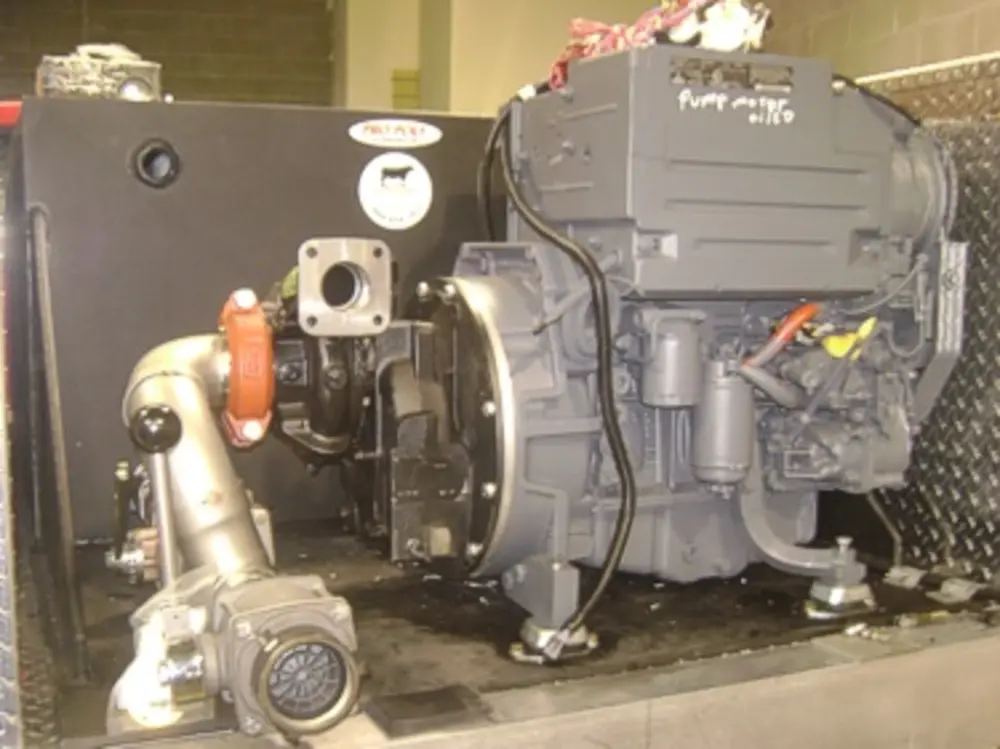 Exterior view of small fire truck showing cab, body compartments, and wheel/tire area.