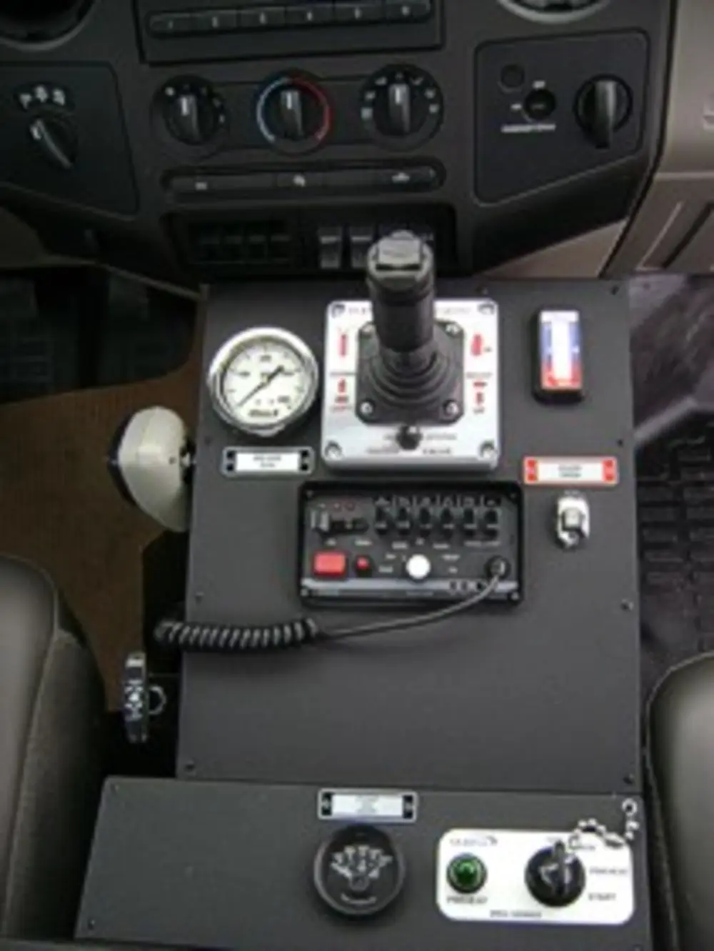 Exterior view of small fire truck showing cab, body compartments, and wheel/tire area.